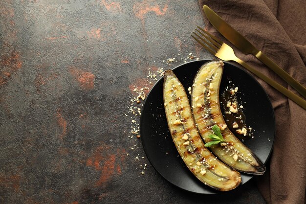 Concetto di cibo gustoso con banana grigliata su sfondo scuro con texture