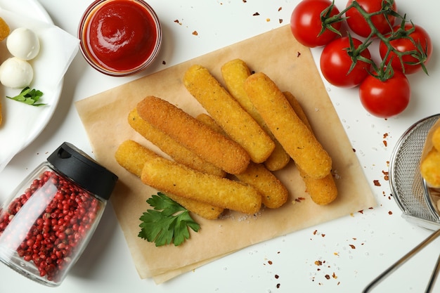 Concetto di cibo gustoso con bastoncini di formaggio su sfondo bianco