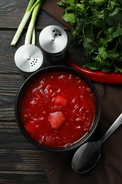 Concetto di cibo gustoso con borscht e ingredienti su legno