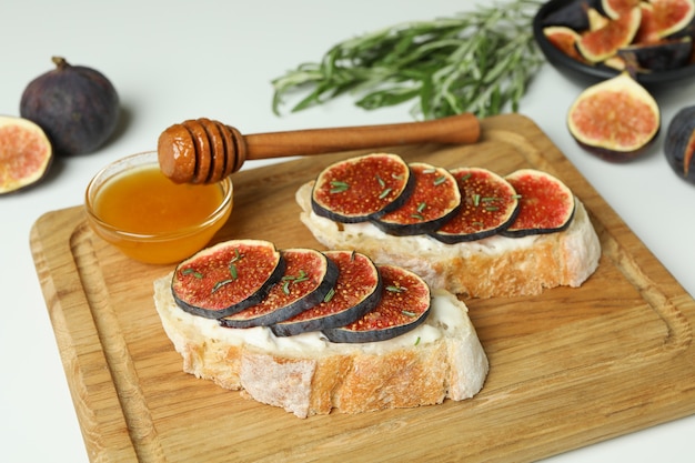 Concetto di cibo gustoso con bruschetta con fico su sfondo bianco