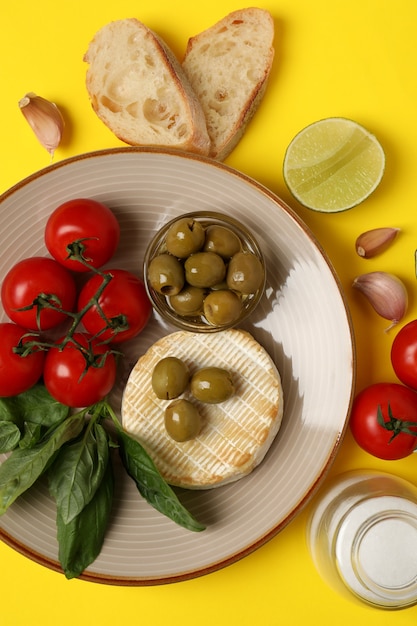 Concetto di cibo gustoso con camembert alla griglia su sfondo giallo.