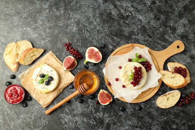 Concetto di cibo gustoso con camembert alla griglia su sfondo nero affumicato.