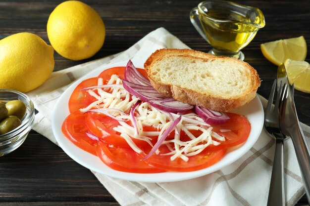 Concetto di cibo gustoso con carpaccio di pomodoro su tavola in legno rustico