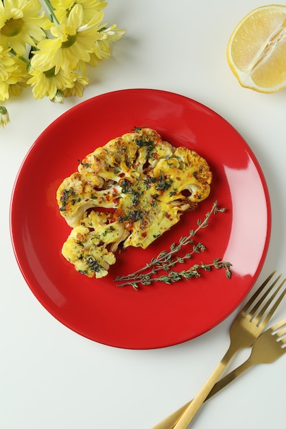 Concetto di cibo gustoso con cavolfiore al forno su sfondo bianco..