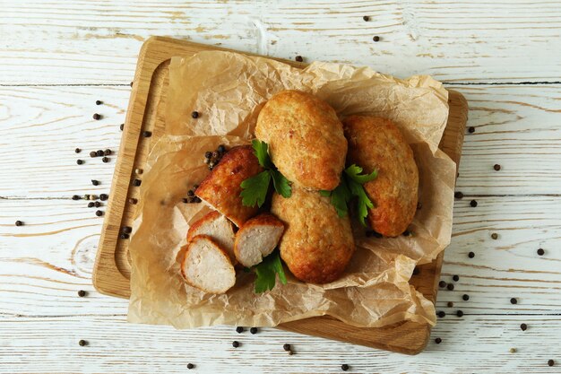 Concetto di cibo gustoso con cotolette sul tavolo di legno bianco