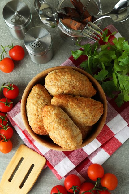 Concetto di cibo gustoso con cotolette sul tavolo strutturato grigio