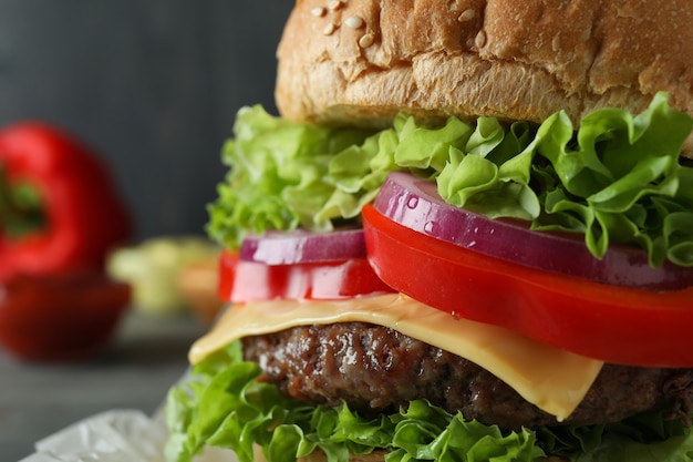 Concetto di cibo gustoso con delizioso hamburger