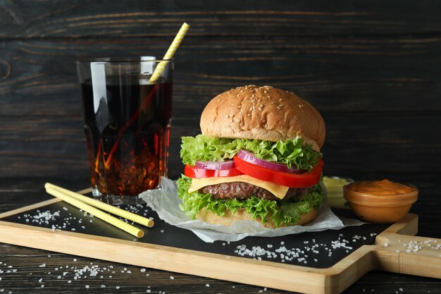 Concetto di cibo gustoso con delizioso hamburger