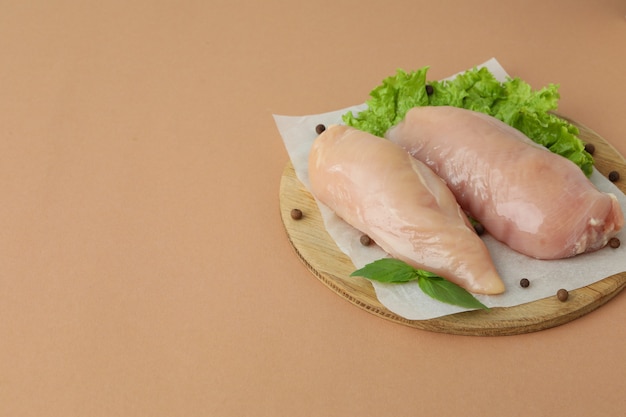 Concetto di cibo gustoso con fette di filetto di pollo crudo su fondo beige