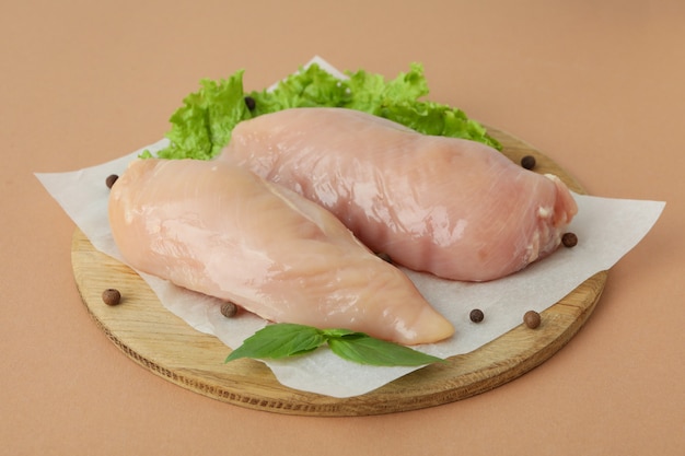 Concetto di cibo gustoso con fette di filetto di pollo crudo su fondo beige