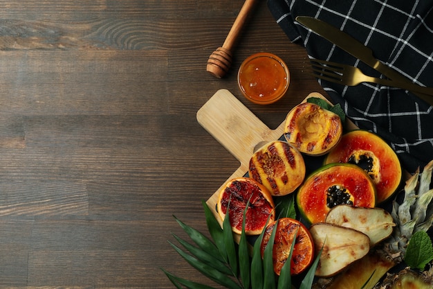 Concetto di cibo gustoso con frutta alla griglia su fondo di legno.