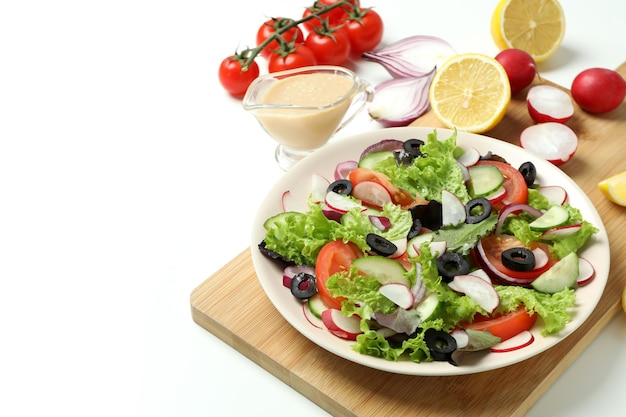 Concetto di cibo gustoso con insalata di verdure con salsa tahini su sfondo bianco