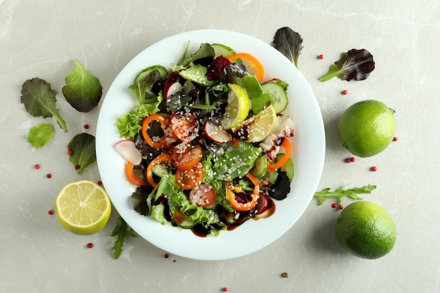 Concetto di cibo gustoso con insalata di verdure con salsa tahini su sfondo strutturato chiaro