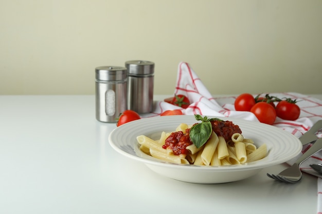 Concetto di cibo gustoso con pasta con salsa di pomodoro sul tavolo bianco