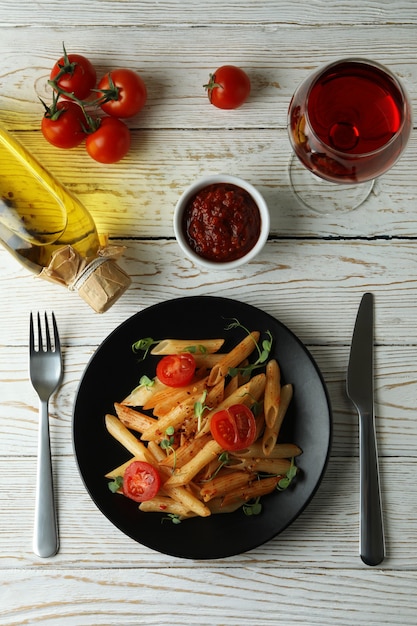 Concetto di cibo gustoso con pasta con salsa di pomodoro sul tavolo di legno bianco