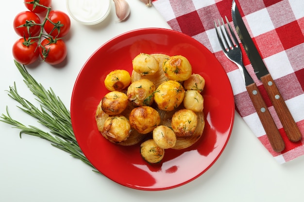 Concetto di cibo gustoso con patate al forno su sfondo bianco.
