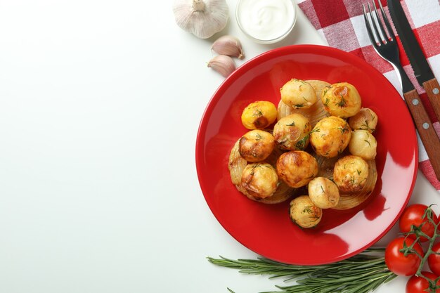 Concetto di cibo gustoso con patate al forno su sfondo bianco.