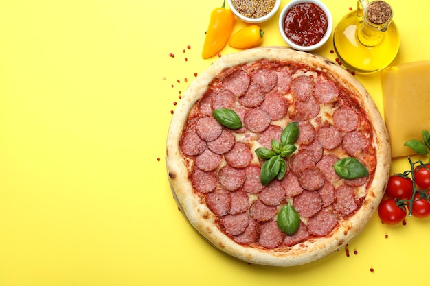 Concetto di cibo gustoso con pizza al salame su sfondo giallo