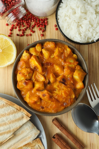 Concetto di cibo gustoso con pollo tikka su fondo in legno