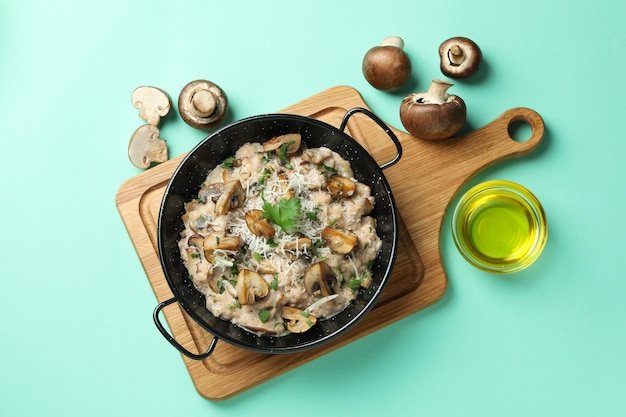 Concetto di cibo gustoso con risotto ai funghi su sfondo di menta