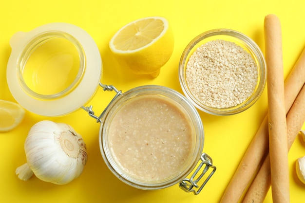 Concetto di cibo gustoso con salsa tahini su sfondo giallo