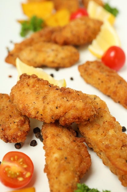 Concetto di cibo gustoso con strisce di pollo su sfondo bianco