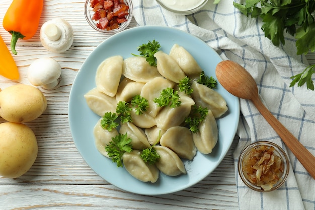 Concetto di cibo gustoso con vareniki o pierogi su tavola di legno