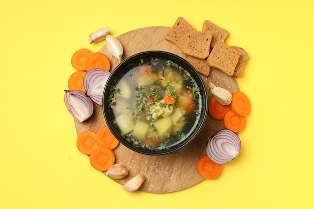 Concetto di cibo gustoso con zuppa di pollo su sfondo giallo