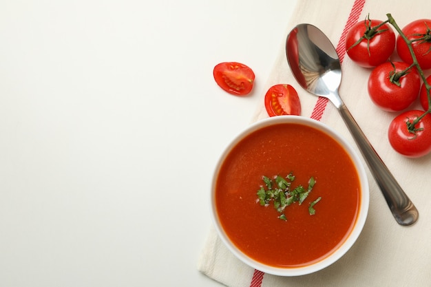 Concetto di cibo gustoso con zuppa di pomodoro su bianco