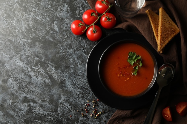 Concetto di cibo gustoso con zuppa di pomodoro su smokey nero