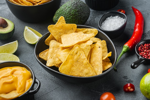 Concetto di cibo messicano. Nachos - patatine di totopos di mais giallo con varie salse, sul tavolo grigio