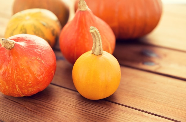 concetto di cibo, raccolto, stagione e autunno - primo piano di zucche sul tavolo di legno a casa