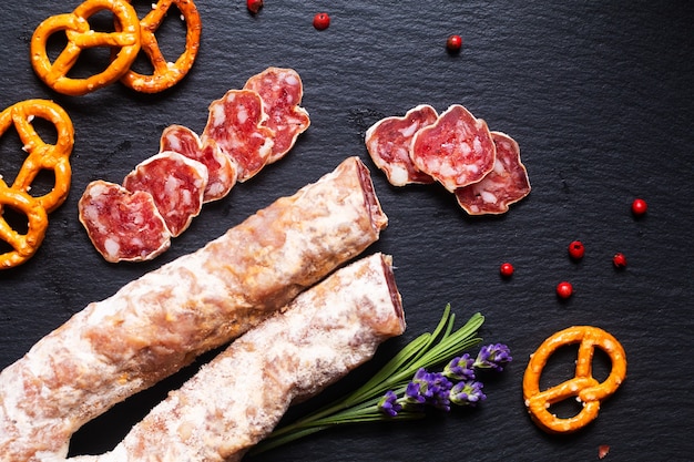 Concetto di cibo salame francese organico Salsiccia su tavola di ardesia nera con spazio copia