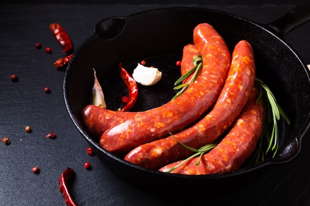 Concetto di cibo Salsicce piccanti francesi Merguez in padella di ferro con spazio di copia