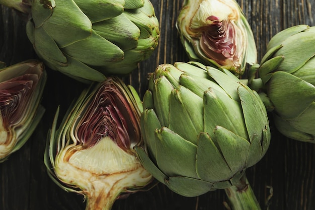 Concetto di cibo sano con il carciofo su fondo di legno