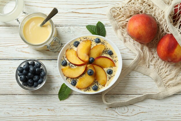 Concetto di cibo sano con yogurt alla pesca sul tavolo di legno bianco