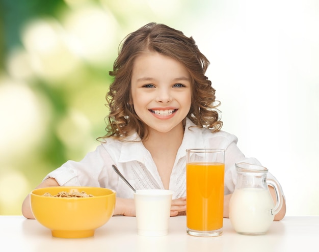 concetto di cibo sano, mangiare, persone e bambini - bella ragazza sorridente felice che fa colazione su sfondo verde