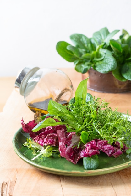 Concetto di cibo sano Mix di insalata di verdure in lamiera verde su sfondo di legno