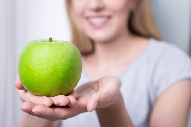 Concetto di cibo sano - primo piano di mela verde in mano femminile