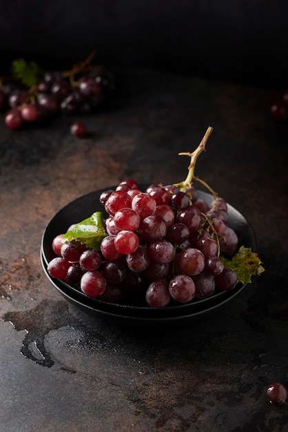 Concetto di cibo sano vegn. Uva rossa sulla tavola nera