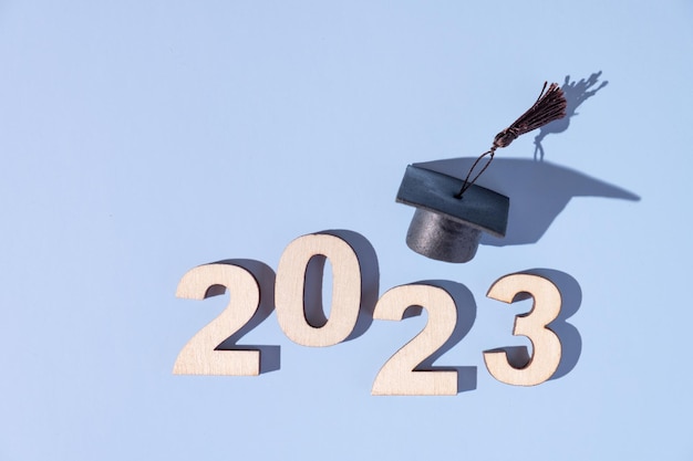 Concetto di classe 2023 Numeri 2023 con cappuccio graduato nero su sfondo colorato