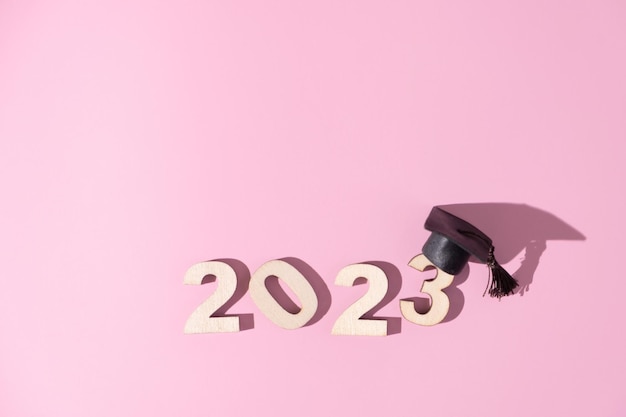 Concetto di classe 2023 Numeri 2023 con cappuccio graduato nero su sfondo colorato