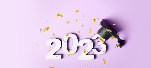 Concetto di classe 2023 Numero in legno 2023 con tappo graduato su sfondo colorato con tinsel volante