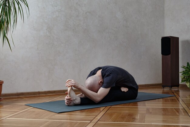 Concetto di classe di esercizio di pratica di yoga. Uomo che fa yoga