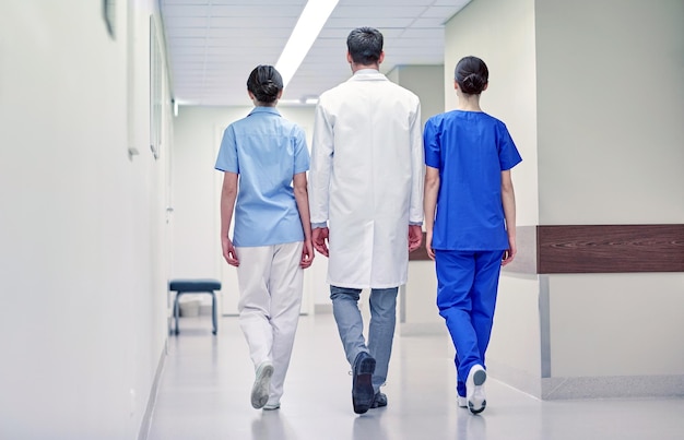 concetto di clinica, professione, persone, assistenza sanitaria e medicina - gruppo di medici o medici che camminano lungo il corridoio dell'ospedale