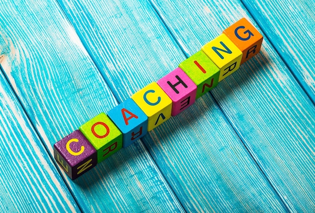 concetto di coaching parola su cubi colorati in legno