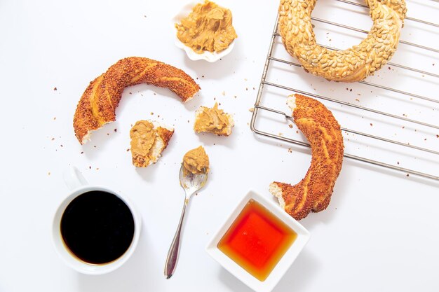 Concetto di colazione bagel turco con miele di caffè e burro di arachidi Immagine isolata su bianco