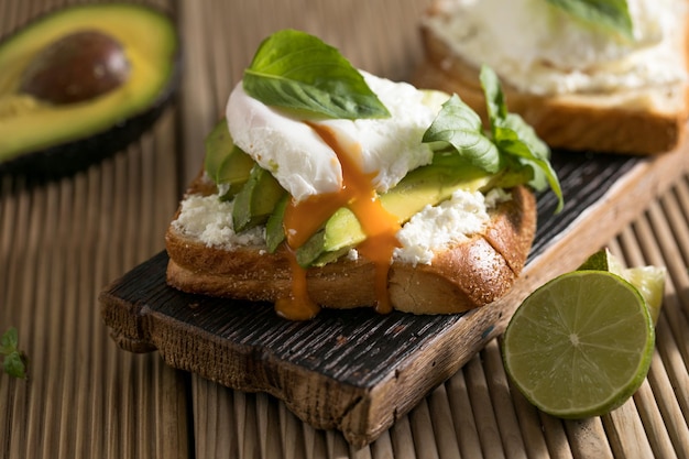 Concetto di colazione pane tostato con uovo in busta di avocado a fette