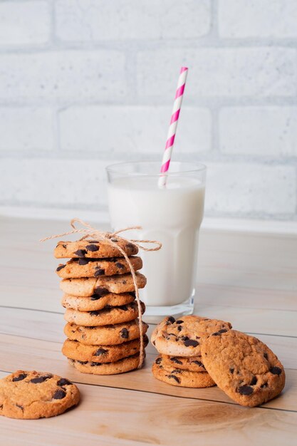 Concetto di colazione sana con bicchiere di latte e biscotti cotti sul tavolo di legno per la sovrapposizione