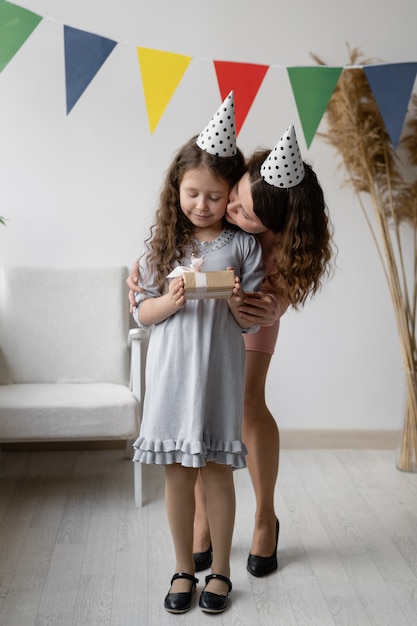 Concetto di compleanno. Una giovane donna e la sua bellissima figlia sorridono e ridono.